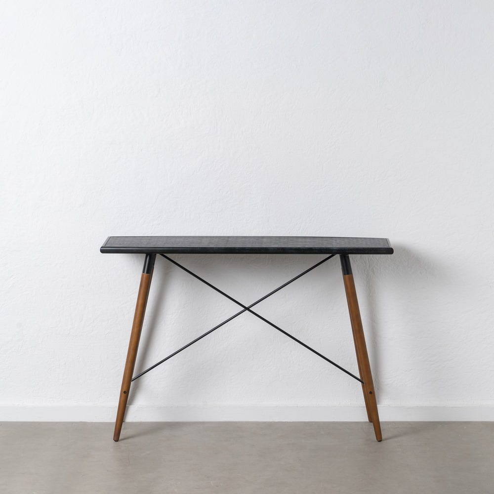 La consola en DM y metal Oslo presenta un diseño minimalista con una elegante tapa rectangular negra, patas de madera y barras transversales de metal. Fabricada con materiales de alta calidad, se destaca elegantemente contra una pared blanca sobre un piso gris claro, lo que encarna un diseño moderno.