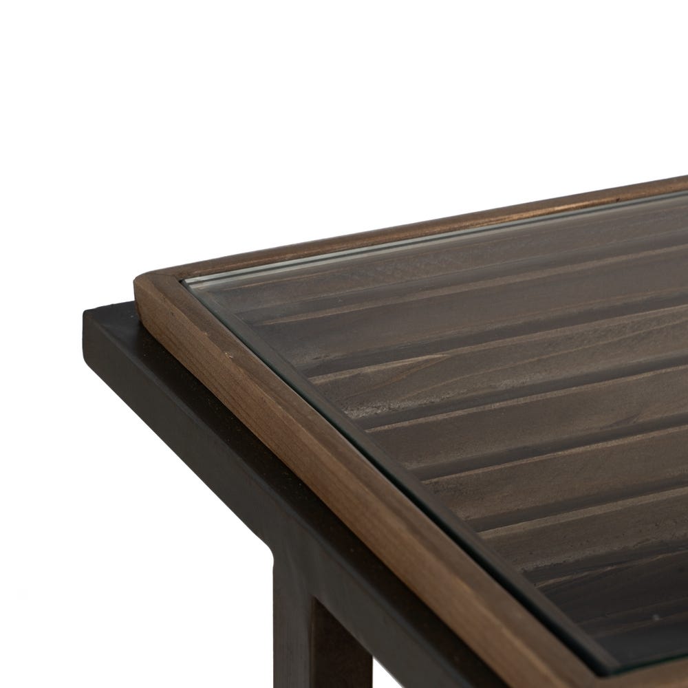 Primer plano de una esquina de la mesa consola Tessa con tapa de cristal y borde de madera, que muestra su elegante diseño moderno y su excepcional artesanía en madera de abeto.