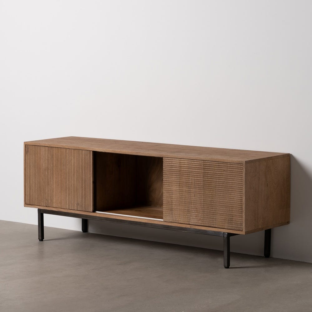 El "Mueble TV en madera de mango natural Estocolmo" cuenta con un diseño minimalista elegante con dos compartimentos cerrados y una sección central abierta, todo ello sostenido por patas de metal negro contra una pared neutra.