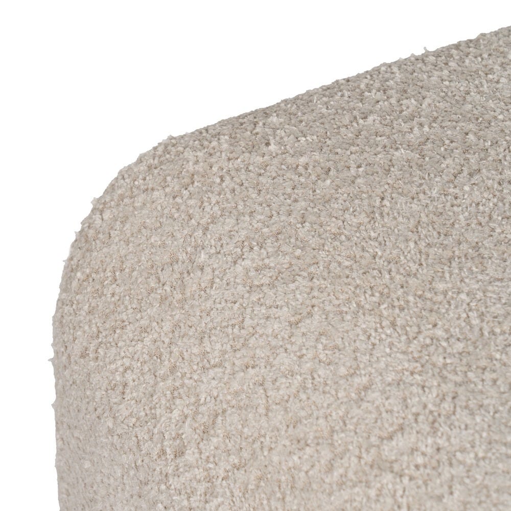 Primer plano de una superficie de tela texturizada de color beige que muestra su aspecto granulado y suave. El Puf en Borreguito Beige Liven irradia comodidad y elegancia, perfecto para cualquier ambiente.