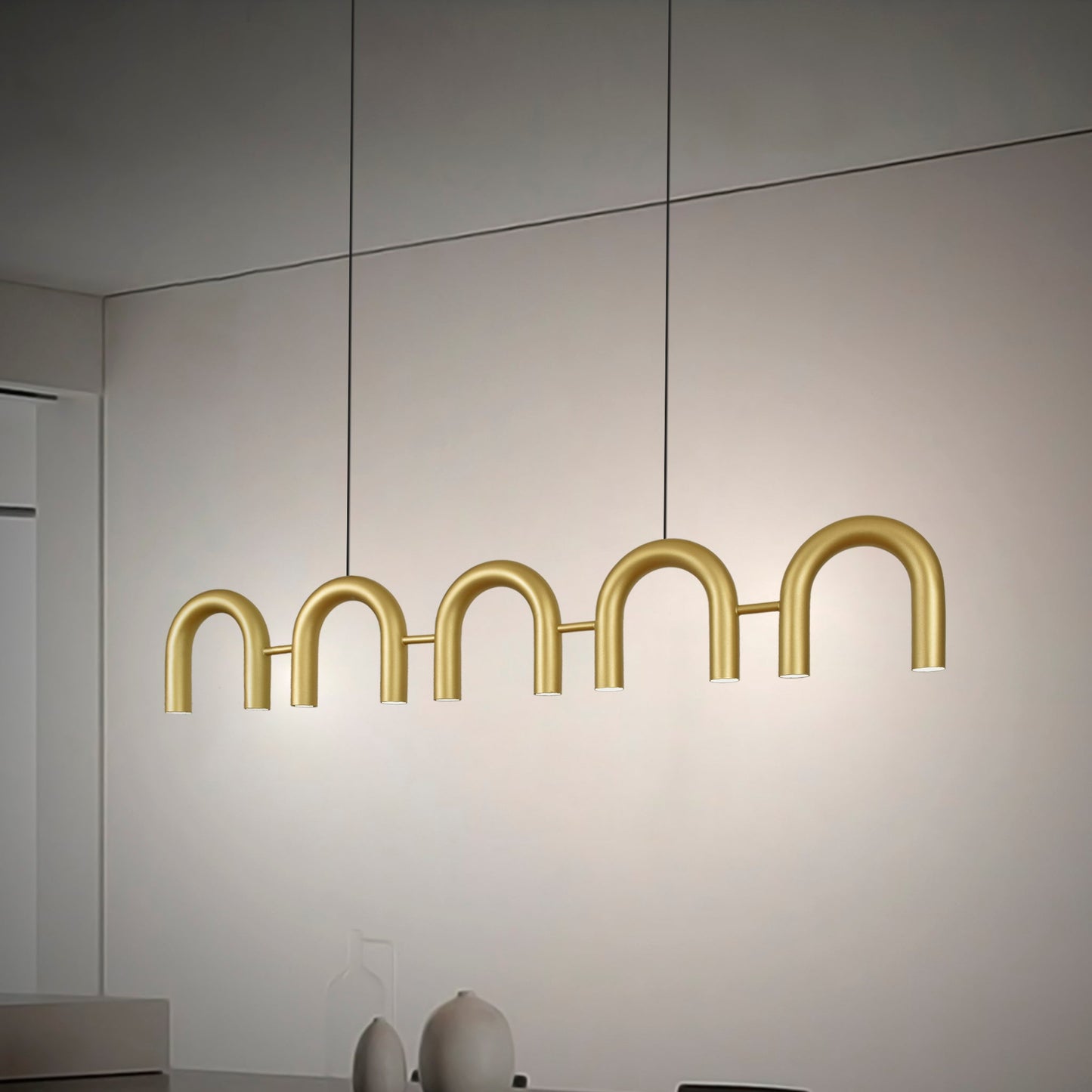 La Lámpara de techo en acero Rhea 5 presenta un elegante diseño moderno con luces en forma de arco, ofreciendo una exquisita iluminación ambiental en cualquier ambiente interior minimalista.