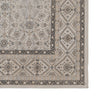 Vista de esquina de una alfombra ornamental beige con motivos florales y un borde geométrico intrincado, que rezuma sofisticación y comodidad. Este diseño versátil se asemeja a la Alfombra de viscosa en gris Nimbus, que combina elegancia con un estilo atemporal.