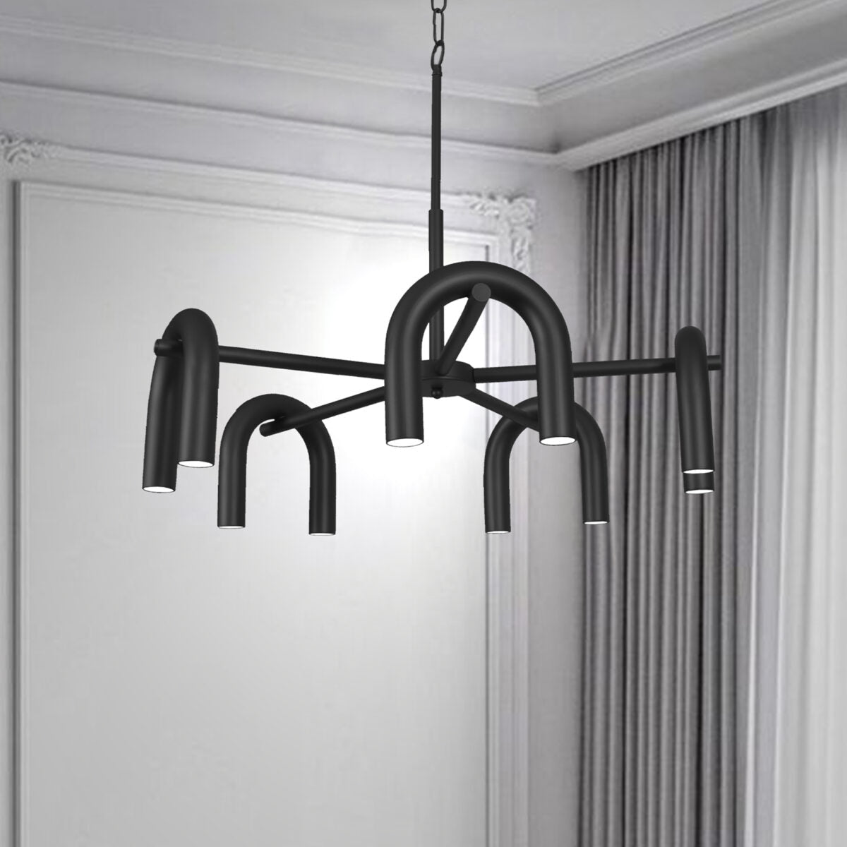 La lámpara de techo en acero X-Rhea 5, negra y moderna con brazos tubulares curvados y tecnología LED, cuelga en una habitación con paredes blancas y cortinas grises para una elegante iluminación moderna.