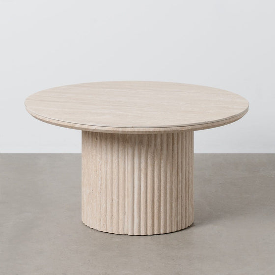 De diseño elegante, la Mesa de Centro en DM y Piedra Sinterizada Beige Odel presenta una base cilíndrica acanalada, que sirve como la pieza central perfecta contra un piso gris y un fondo blanco nítido.