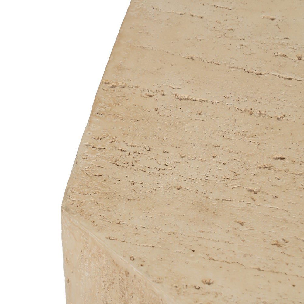 Primer plano de la superficie de piedra travertino beige en una Mesa auxiliar Hexagonal de Magnesio Beige Magnus, resaltando su textura natural y picaduras, ideal para un diseño moderno.