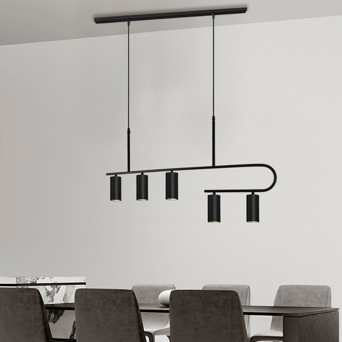 Comedor moderno con la Lámpara de techo en acero S-Toru 5 en color negro, que proporciona una iluminación sofisticada sobre una mesa rodeada por seis sillas grises.