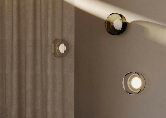 Un interior minimalista presenta dos apliques de pared circulares, realzados por el Aplique de pared Ipon y cortinas beige texturizadas con iluminación LED suave.