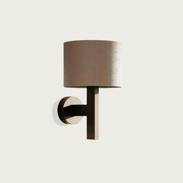 El Aplique de pared Rems presenta una pantalla cilíndrica y un elegante diseño minimalista, proporcionando una iluminación óptima sobre un fondo liso.