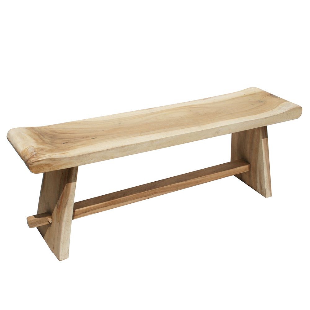 La Banqueta en Madera de Meh Sate es un banco de madera con un asiento de borde vivo, patas en ángulo y una barra camilla horizontal, elaborado con madera maciza duradera para un diseño rústico.
