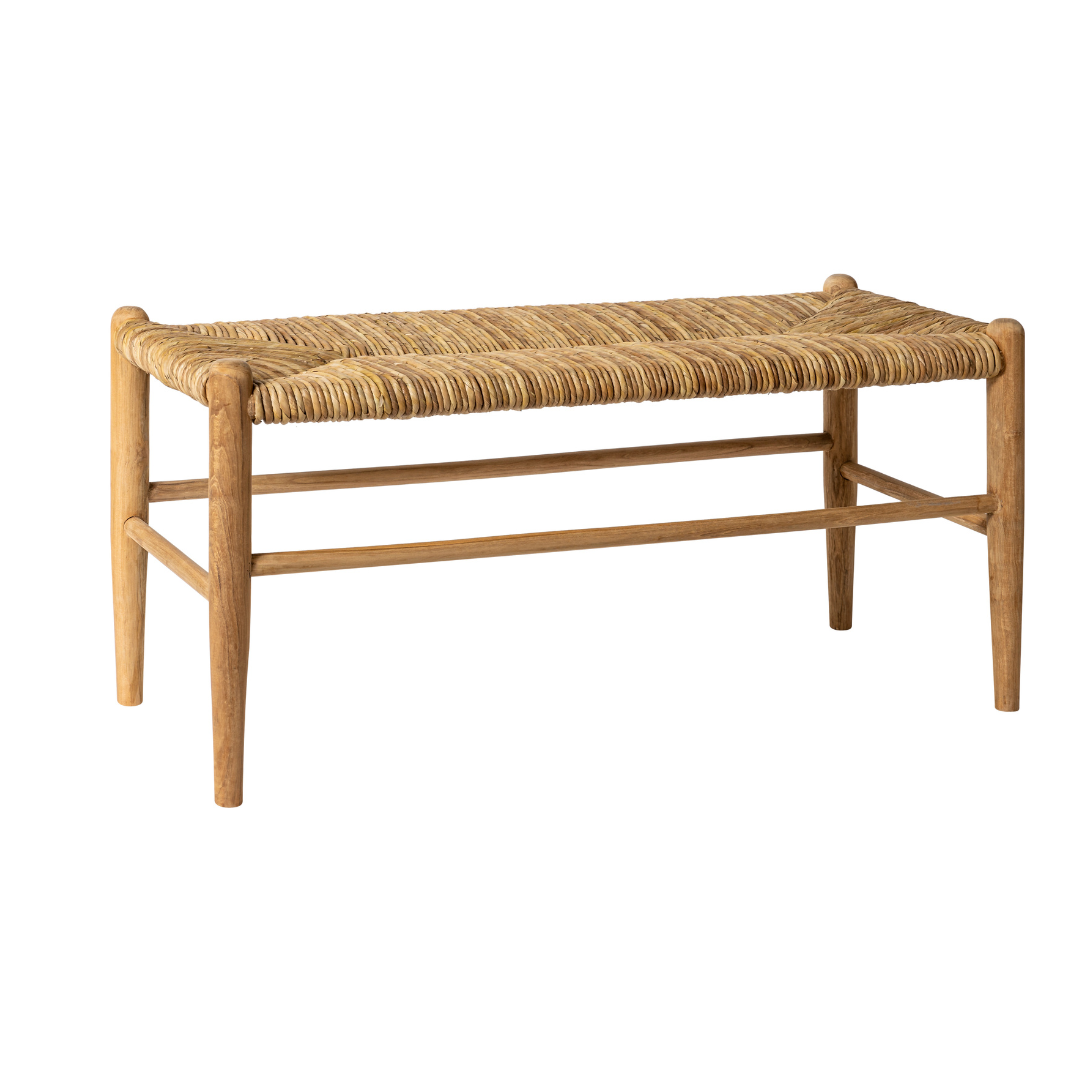 La Banqueta en Madera de Teca y Ratán Manado resalta por su diseño artesanal y elegante, con estructura de teca y asiento de ratán natural sobre un fondo blanco.