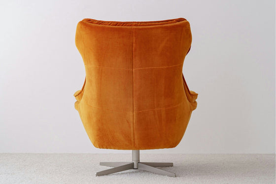 Elegante y moderna, la Butaca Giratoria Tapizada en Terciopelo Naranja presenta un diseño de respaldo alto. Esta silla giratoria de terciopelo naranja, colocada sobre una alfombra gris, personifica el estilo de los muebles elegantes con su impresionante diseño moderno desde atrás.