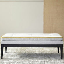  El Banco Moderno Gris Amarillo Mostaza de la Colección Urbana Chic, con su asiento gris acolchado y sus elegantes patas negras, reposa elegantemente sobre una alfombra texturizada, complementando perfectamente una pared minimalista en cualquier espacio de diseño contemporáneo.