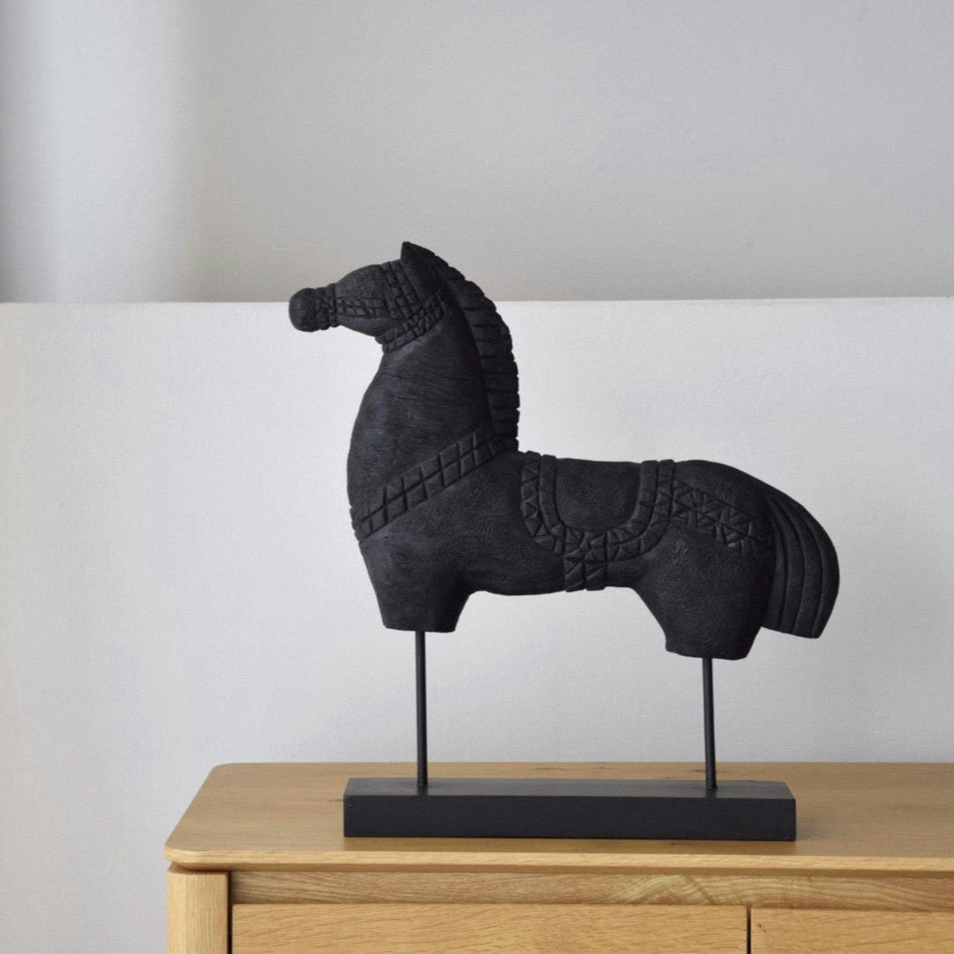 La Figura Decorativa en Madera Tallada Caballo N.3 se alza grandiosamente sobre un gabinete de madera de mango contra una pared gris claro.