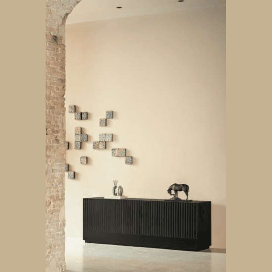 Una habitación minimalista que presenta un gabinete negro con una estatua decorativa de un elefante y jarrones, acompañado de una pared adornada con una variedad de pequeñas obras de arte enmarcadas. El espacio incluye el Aparador Doric 4P4C