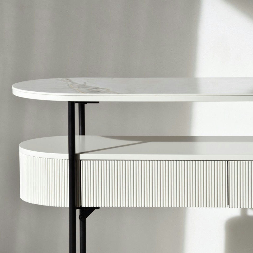 La Consola Oval N.24, con un acabado cerámico blanco y gris con un marco de metal y un diseño de cajones acanalados, se presenta sobre un fondo gris claro. Perfecta para la decoración y el interiorismo, esta pieza realza sin esfuerzo cualquier espacio.