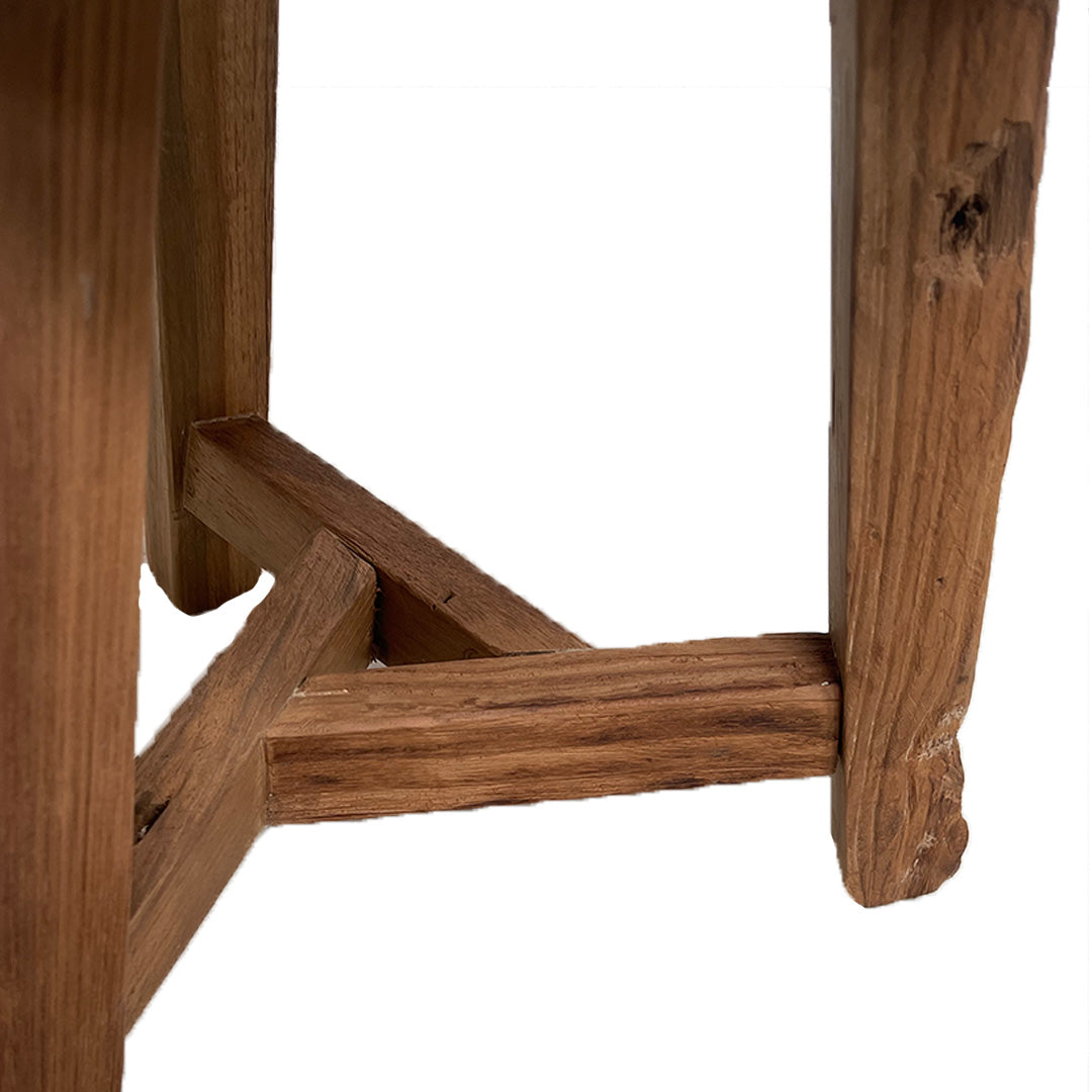 Primer plano de las patas de madera y las vigas de soporte de la Banqueta Rústica en Madera Natural Rustic S, que muestra la veta natural de la madera y las imperfecciones sobre un fondo blanco para un auténtico estilo rústico.