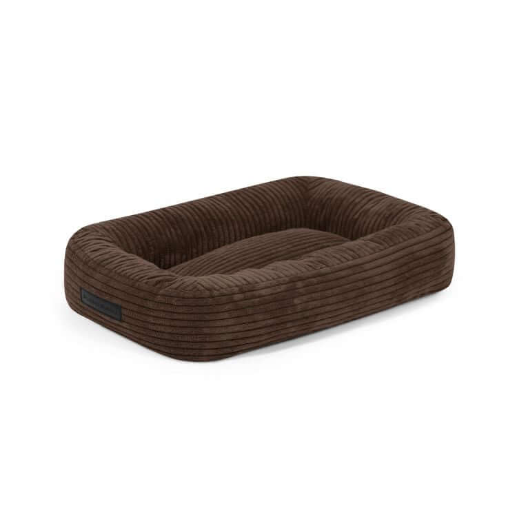 Cama para perro de terciopelo acanalado DOG BED 55 WAVES (55×45×16 cm), rectangular y marrón, con costados elevados y entrada baja frontal, ideal para perros pequeños. Se muestra sobre fondo blanco.