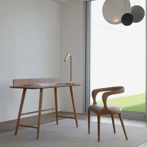 Oficina en casa moderna y minimalista con Escritorio BESK de alta calidad, silla y lámpara de escritorio junto a una gran ventana.