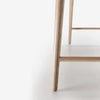 Primer plano de una pata de silla de madera de Escritorio alto BESK sobre fondo blanco.