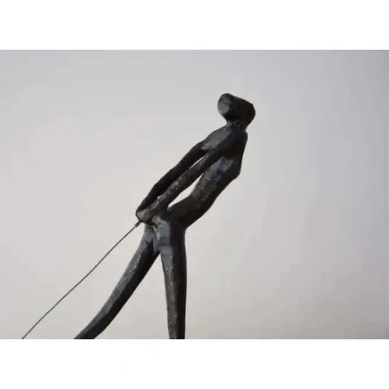 Una escultura de Escultura Arrastre de un hombre sosteniendo un palo, ideal para decoración.