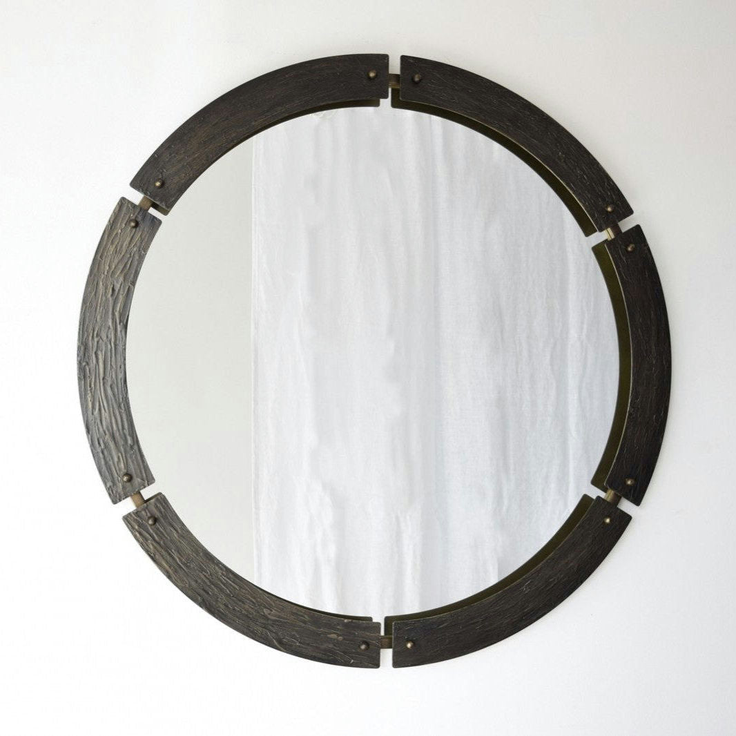 La elegancia contemporánea se refleja en este Espejo Redondo 2, con un marco de relieve en metal que adorna la pared blanca.