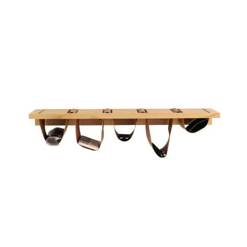 El Estante de pared Jarre 110 x 30 cuenta con un estante de madera de pino macizo con cinco ranuras, cada una adornada con correas de cuero marrón en forma de bucle que sostienen objetos negros y metálicos.