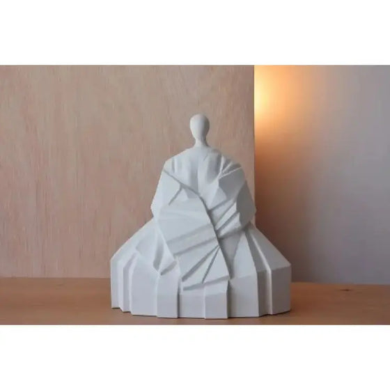 Una escultura blanca Figura Cerámica Japonesa Manga Extendida Blanco Mate, un arte, encima de una mesa de madera.