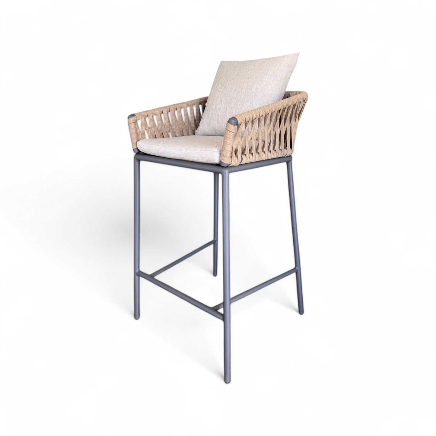 El taburete de exterior INDIGO presenta un diseño moderno con estructura de aluminio gris antracita y cuerda beige, acompañado de cojines claros para asiento y respaldo, todo sobre fondo blanco.