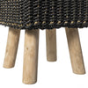 Primer plano de Puff de seagrass negro y natural Black/Nat 33x46 con una tapa negra tejida que rezuma calidad artesanal, sostenida por cuatro patas cilíndricas de madera que encarnan el diseño moderno.