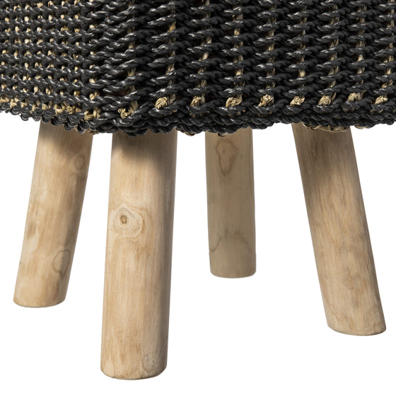 Primer plano de Puff de seagrass negro y natural Black/Nat 33x46 con una tapa negra tejida que rezuma calidad artesanal, sostenida por cuatro patas cilíndricas de madera que encarnan el diseño moderno.