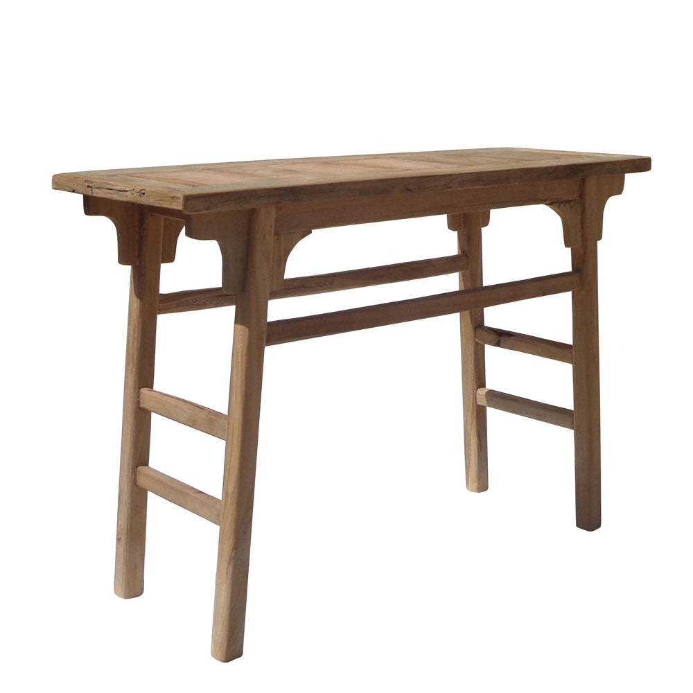 La Consola en Madera de Teca Reciclada Luku tiene forma rectangular, cuatro patas y soportes sencillos estilo rústico, fabricados con madera de teca reciclada. Se muestra sobre fondo blanco.