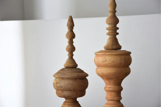 Dos Figuras decorativas en madera de mango tallada Loa, que muestran intrincados diseños artesanales, están elegantemente colocadas sobre un fondo blanco prístino.