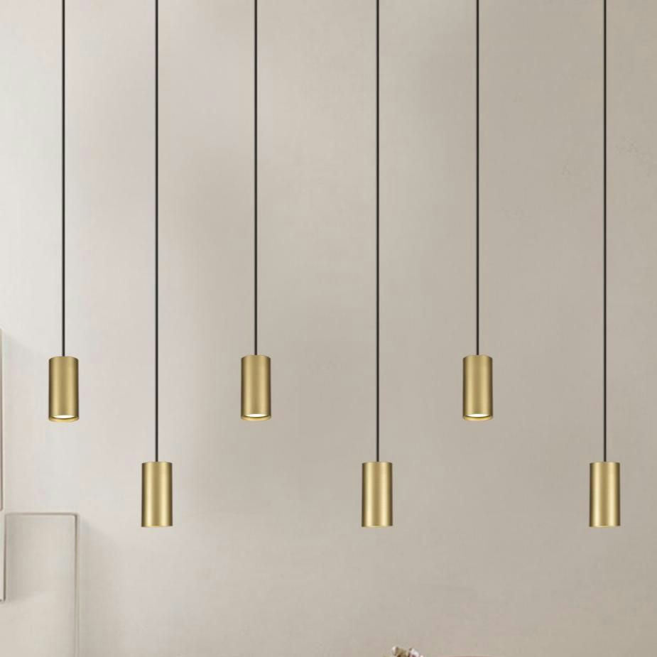 La pared beige está acentuada por seis Lámparas de Techo Colgantes Dorado 3043-1C, que ofrecen un toque perfecto de iluminación moderna.