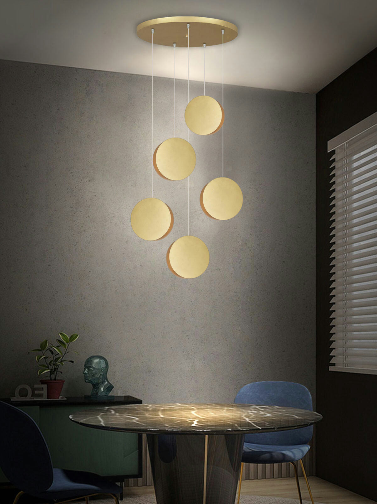 Un comedor moderno cuenta con una mesa redonda, una silla azul, una escultura y la Lámpara de Techo Colgante Moderna 3223-5C con un diseño minimalista.