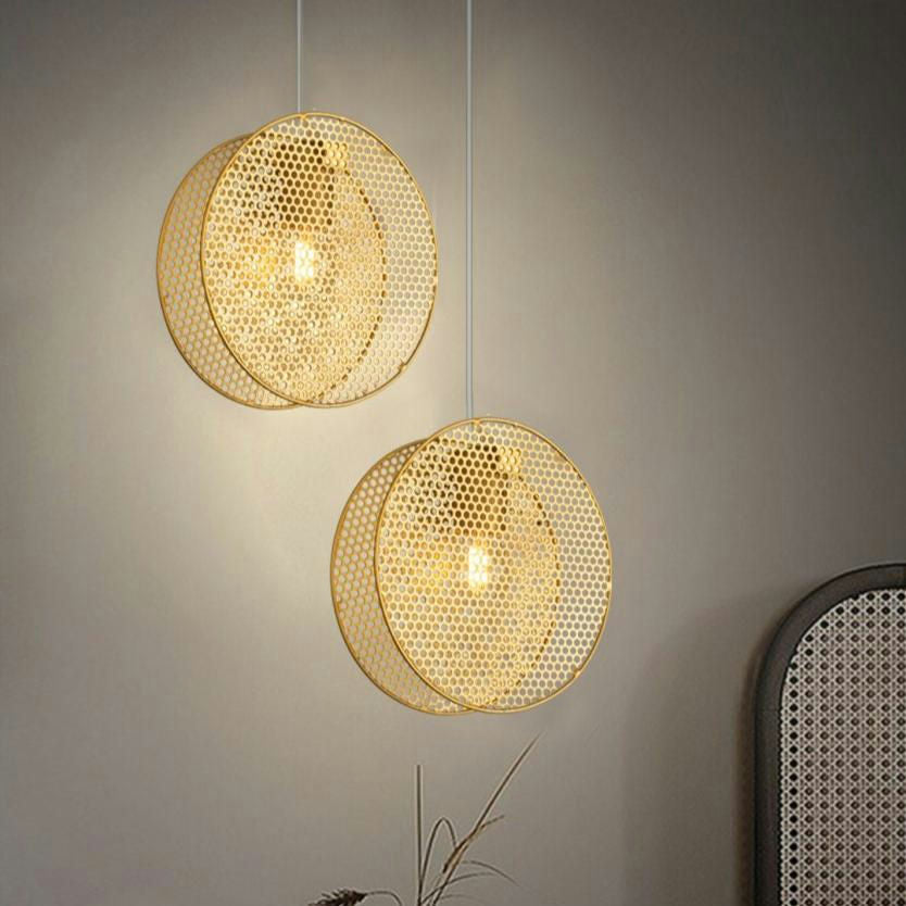 Dos lámparas de techo colgantes esféricas de metal 3224-1C cuelgan del techo contra una pared gris y emiten un suave resplandor. Su diseño contemporáneo añade elegancia y modernidad a la habitación, mostrando el encanto del acero dorado en perfecta armonía.