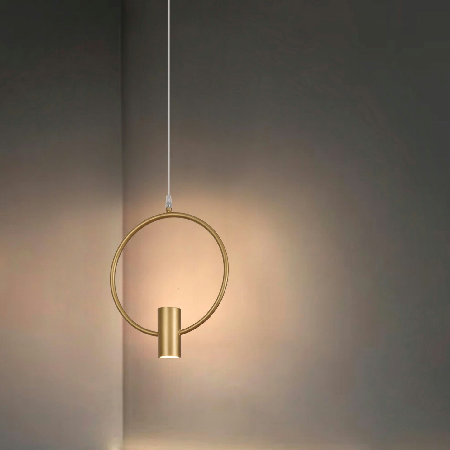 La Lámpara de Techo Colgante Moderna Dorada 6902-1C, con su diseño circular y bombilla cilíndrica, proyecta un brillo suave y cálido contra una pared lisa, exudando sofisticación y elegancia.
