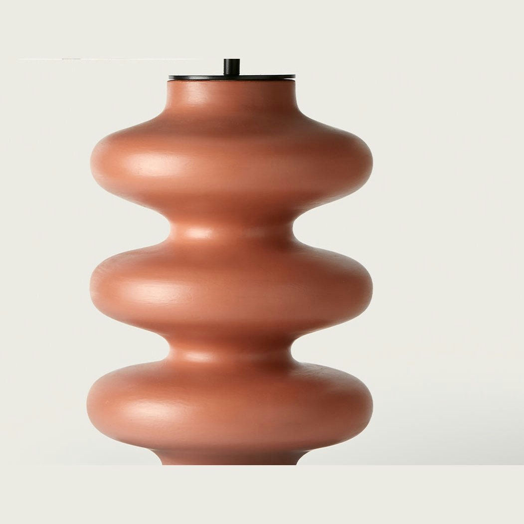 La lámpara de mesa Adon presenta una base escultural marrón con un diseño ondulado y apilado que refleja el diseño orgánico. Ideal para quienes marcan tendencia en decoración, esta lámpara aporta un toque artístico a cualquier entorno sencillo.