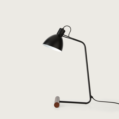 La Lámpara de mesa Aito es una elegante lámpara negra con un diseño moderno, que presenta un soporte curvo y una base de madera, que muestra un estilo industrial sobre un fondo blanco liso, ofreciendo una iluminación adaptable para cualquier entorno.
