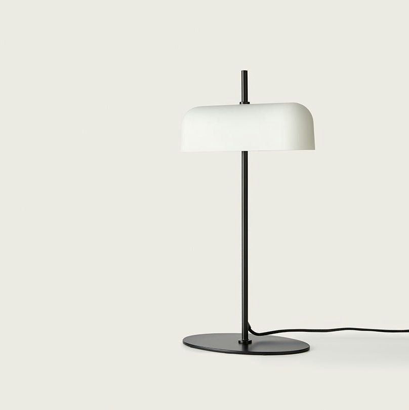 La lámpara de mesa Atil, con un diseño de metal negro con una base ovalada y una pantalla blanca horizontal, incorpora a la perfección el diseño minimalista e incluye un cable de alimentación.