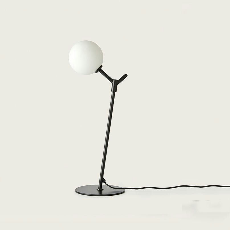 La Lámpara de mesa Atom presenta una pantalla blanca redonda minimalista sobre un elegante soporte negro, con una base plana en ángulo para una iluminación focalizada perfecta, realzando perfectamente los interiores contemporáneos.
