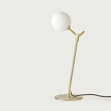 Lámpara de mesa Atom moderna de color dorado, con pantalla globo blanca, sobre un fondo liso.