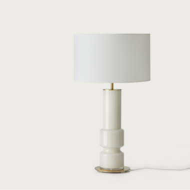 La Lámpara de mesa Lusa, con su aspecto moderno con una base cilíndrica blanca y una pantalla en forma de tambor, encarna un estilo atemporal cuando se coloca con gracia sobre una superficie plana.