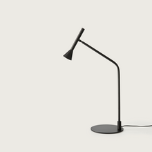  Lámpara de mesa Lyb moderna de color negro con cuello ajustable, colocada a la derecha, sobre un fondo blanco.
