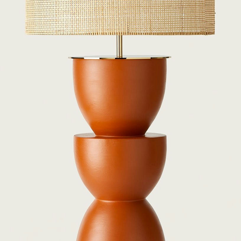 La lámpara de mesa Metric presenta una pantalla tejida y una elegante base geométrica apilada de color naranja, ideal para infundir decoración moderna en cualquier espacio.