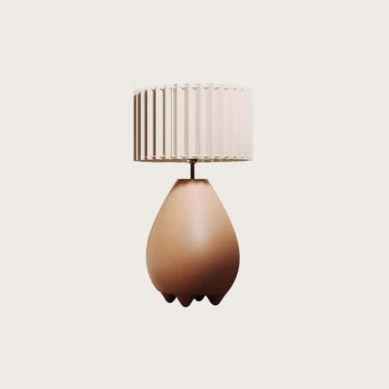 Lámpara de mesa Obrie en forma de pera, color marrón claro, con detalles plisados y diseño orgánico, montada sobre un fondo blanco.