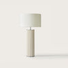 Lámpara de mesa Onica contemporánea con base cilíndrica de acero y una pantalla blanca lisa, aislada en un fondo blanco.