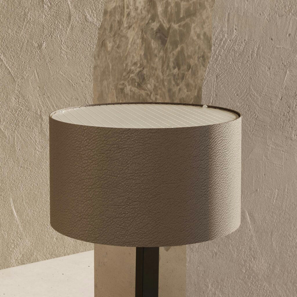 La lámpara de mesa Rems cuenta con un diseño redondo en color beige con una superficie texturizada y una parte superior con patrón de cuadrícula, que armoniza a la perfección con una pared texturizada. Su estilo moderno proporciona una iluminación ambiental ideal, realzando la calidez y creando un ambiente acogedor en cualquier habitación.
