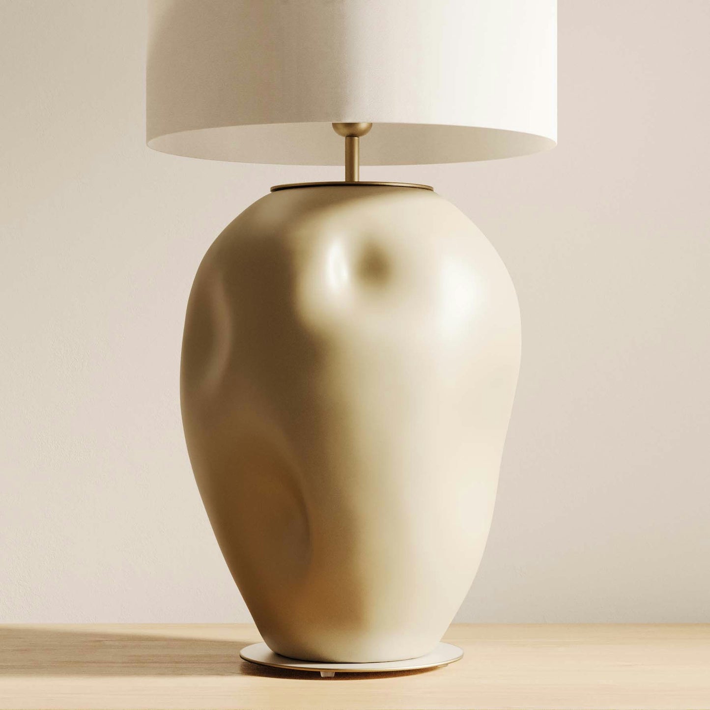 La Lámpara de Mesa Ural, con su base de cerámica beige en forma de torso humano y rematada con una pantalla cilíndrica blanca, reposa elegantemente sobre una superficie de madera, proporcionando encanto artístico y una iluminación eficiente.