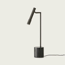  La lámpara de mesa Ycro en color negro cuenta con un diseño elegante y minimalista con una base cilíndrica y un brazo ajustable, proporcionando una iluminación funcional que se alimenta fácilmente mediante un cable.