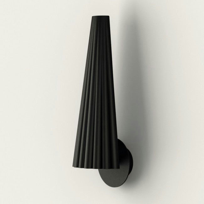La Lámpara de pared Bion, montada en la pared, presenta un diseño cónico negro con textura acanalada y base circular, emitiendo un diseño cómodo y encarnando el minimalismo moderno sobre un fondo claro.